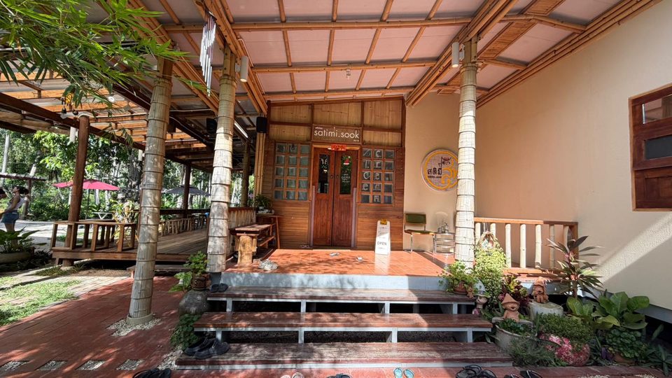 The Satimi.Sook building from the garden path, its wooden porch open to the trees