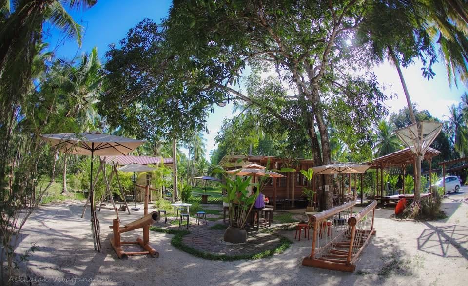 The garden at Satimi.Sook, with parasols under the coconut palms
